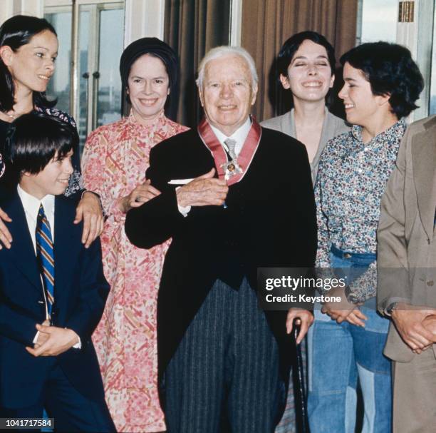 Actor and director Sir Charlie Chaplin with his family at the Savoy Hotel in London, after receiving a KBE, 4th March 1975. From left to right, his...