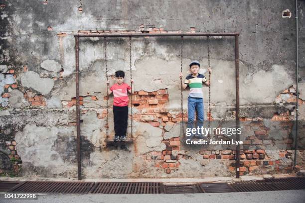 brothers stand on swing - george town penang stockfoto's en -beelden