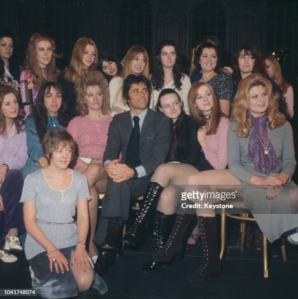 French singer Sacha Distel with a group of female performers at the Theatre Royal on Drury Lane, London, 7th March 1971. He is holding auditions for...