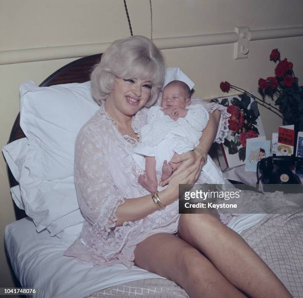 English actress Diana Dors with her four-day-old son Jason at a nursing home in London, UK, 1969. Jason's father is actor Alan Lake.