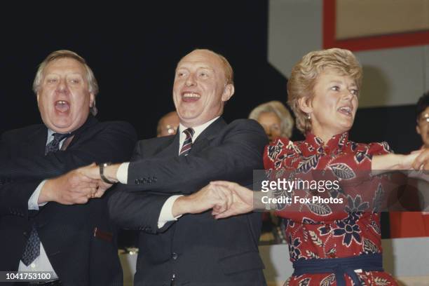 From left to right, British Labour politicians Roy Hattersley, Neil Kinnock and Glenys Kinnock singing at the Labour Party Conference, UK, November...