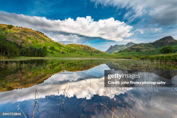 blea tarn symmetrical incoming clouds. lake district national park. uk. - ambleside bildbanksfoton och bilder