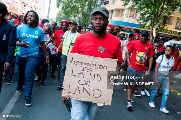 Students wearing clothes from the Economic Freedom Fighters, an opposition political party in South Africa, march through the streets in...