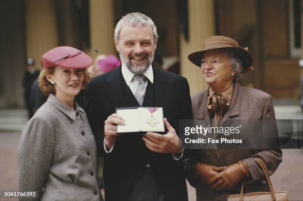 Welsh actor Sir Anthony Hopkins receives a CBE at Buckingham Palace in London, 3rd November 1987. He is accompanied by his wife Jennifer and mother...