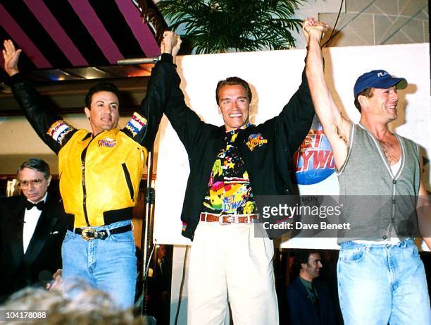 Sylvester Stallone, Arnold Schwarzenegger and Bruce Willis attend the grand opening of Planet Hollywood London on May 17, 1993 in London, England.
