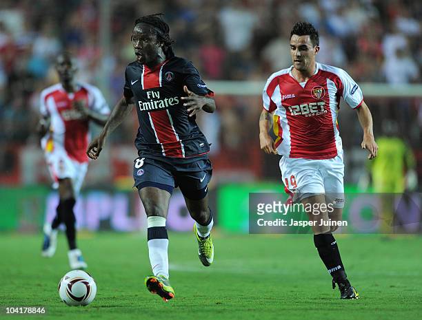 Peguy Luyindula of Paris Saint Germain runs for the ball with Luca Cigarini of Sevilla during the UEFA Europa League group J match between Sevilla...