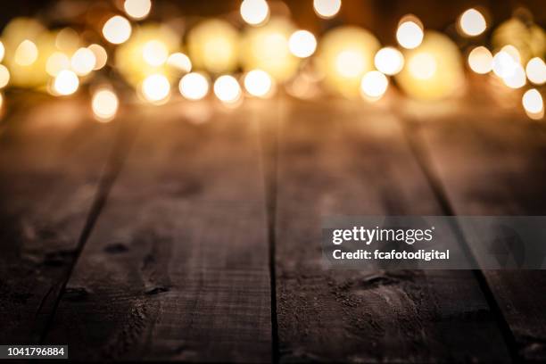 leere rustikalen holztisch mit unscharfen weihnachtsbeleuchtung im hintergrund - dark wood stock-fotos und bilder