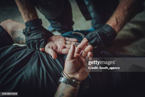 polícia, colocando algemas em um homem - antiterrorismo - fotografias e filmes do acervo