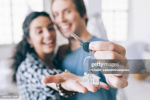 paar vrolijke huiseigenaren een knop ingedrukt - sleutel beveiligingsapparatuur stockfoto's en -beelden