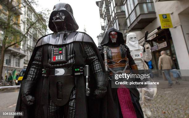 Members of a local 'Star Wars' fan club dressed as characters from the Star Wars movies Darth Vader , Darth Revan and Snowtrooper walk through the...