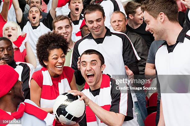 man in crowd catching ball at football match - vangen stockfoto's en -beelden