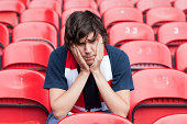 Disappointed football fan in empty stadium