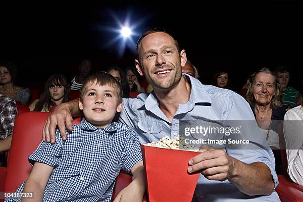 father and son enjoying a movie - spectator parent stock pictures, royalty-free photos & images