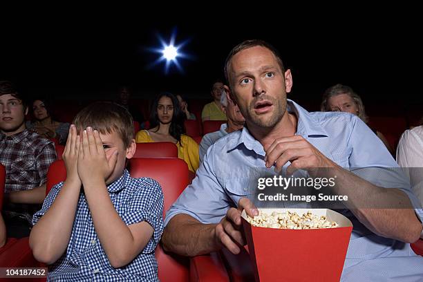 schockiert vater und sohn in movie theater - horror movie stock-fotos und bilder