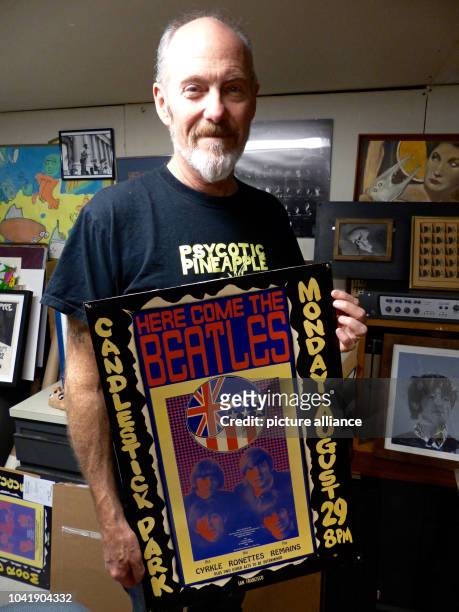Musician and artist Dave Seabury holds the original poster from the Beatles concert on 29 August 1966 in his hands in Orinda, California, USA, 19...