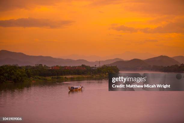 june 2017 hue, vietnam - a fishing boat floats down the perfume river at sunset. - fluß der wohlgerüche stock-fotos und bilder