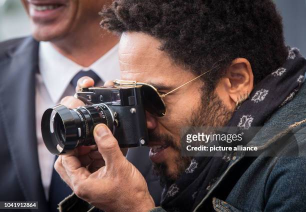 Musician Lenny Kravitz attends the opening of his exhibition as he takes pictures with his camera in the gallery of German camera manufacturer Leica...
