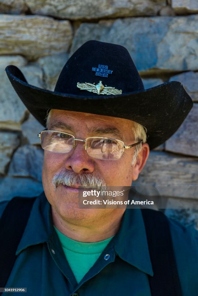 Exterminator with cowboy hat looks for insects and rodents, Oak View, CA