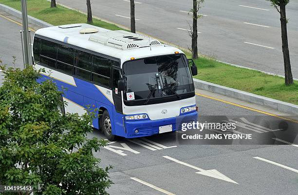 The bus carrying a South Korean Red Cross delegation drives over Korean letters reading "Kaesong" painted on the road at the inter-Korean transit...