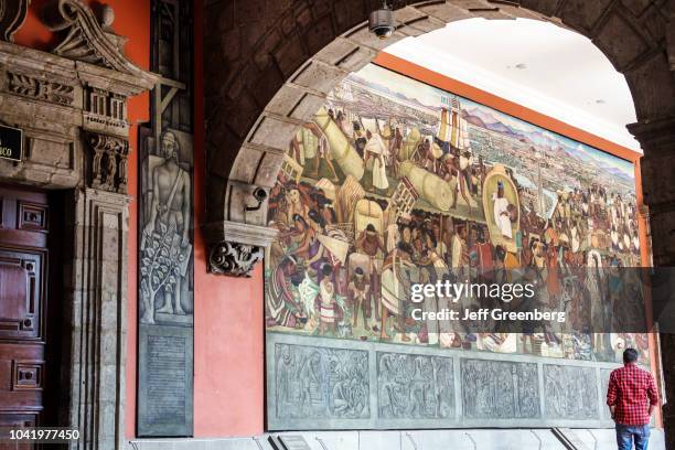 Man looking at the Marketplace Tlatelolco mural at the National Presidential Palace.