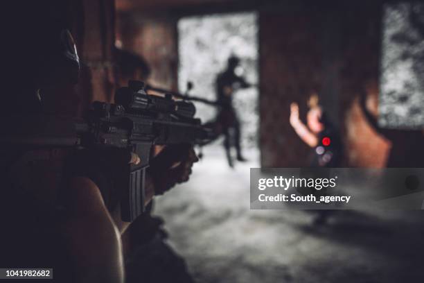 swat team syftar till gangster - swat helmet bildbanksfoton och bilder