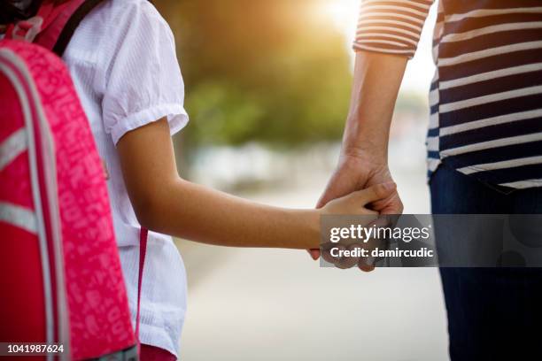 mutter und tochter halten hände - familie anonym stock-fotos und bilder