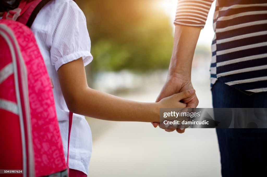 Madre e hija agarrar de la mano