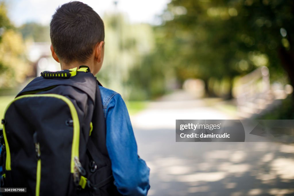 Teenager mit Schultasche, die von der Schule nach Hause gehen