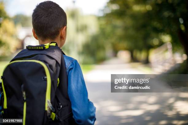 teenage boy with school bag going home from school - kids backpack stock pictures, royalty-free photos & images