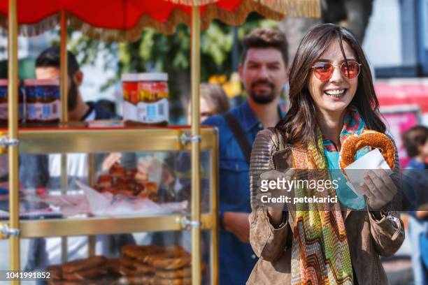 tourist is showing a bagel - simit - turkish bagel stock pictures, royalty-free photos & images
