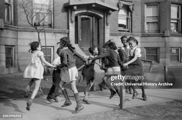 Group of Girls Playing Ring-Around-a-Rosie on Sidewalk in "Black Belt" Neighborhood, Chicago, Illinois, USA, Edwin Rosskam for Office of War...