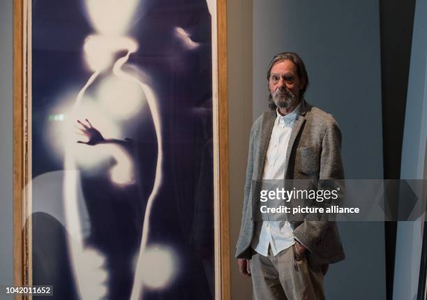 Performing artist Ulay stands next to the artwork 'Self-Portrait' , a life-sized work on polaroid material, in the exhibiton 'Ulay Life-Sized' in...