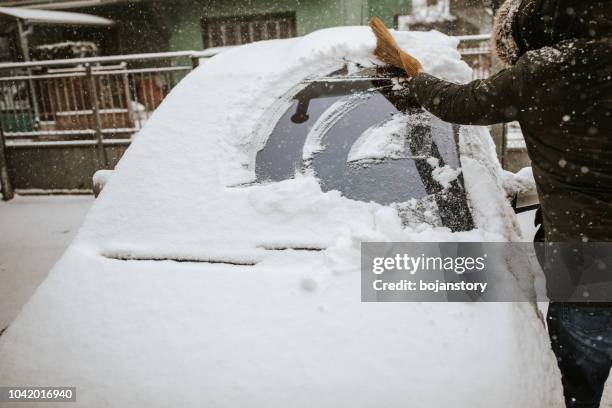 l’homme de neige nettoyage de voiture - covered car photos et images de collection