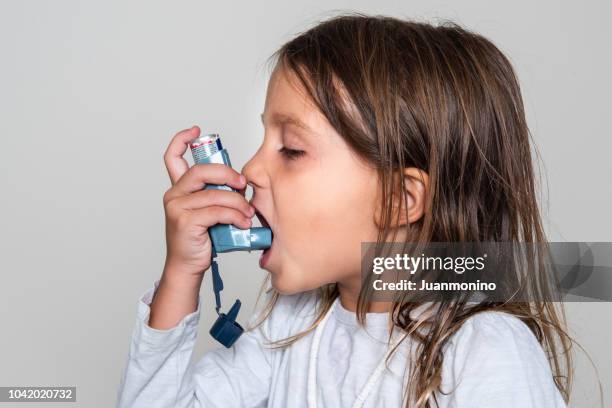 little girl taking her asthma medicine - childhood asthma stock pictures, royalty-free photos & images