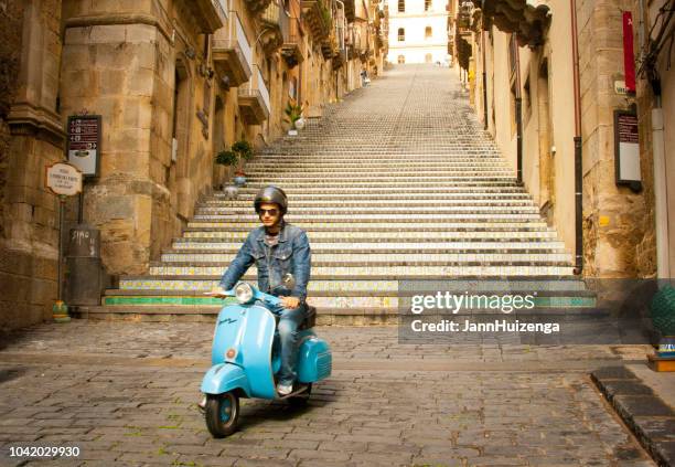 caltagirone, sicilië: hip jongeman op blauwe vespa scooter - vespa stockfoto's en -beelden