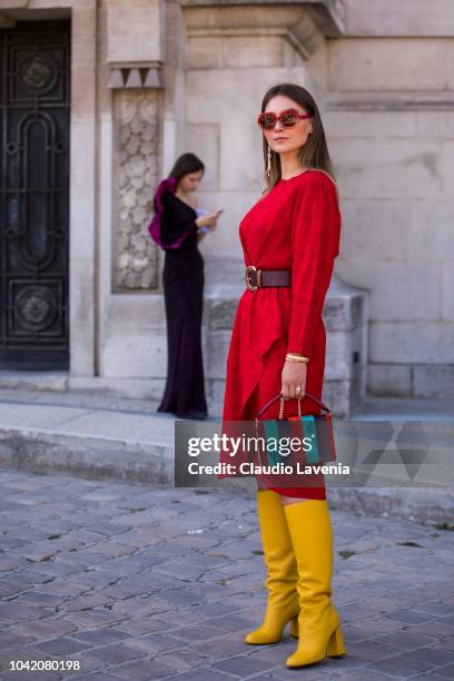 Angelica Ardasheva, wearing a red midi dress, Red Valentino yellow boots and striped colorful bag, is seen after the Paco Rabanne show on September...