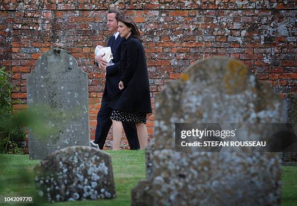 British Prime Minister, David Cameron , carries his baby Florence, as he and his wife Samantha arrive for the funeral of his late father Ian, at St...