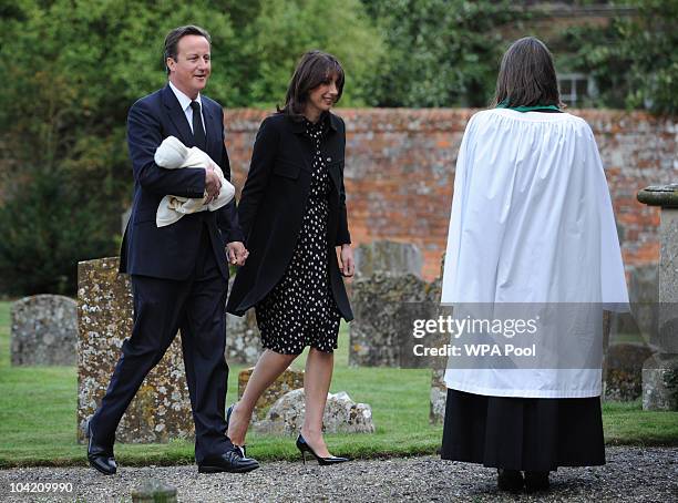 Prime Minister David Cameron, his wife Samantha and their baby daughter Florence are greeted by the Reverend Kate Stacey as they arrive at St...