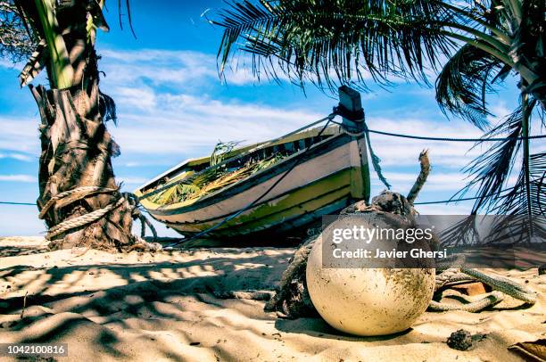 boat sitting in front of the sea, on the beaches of trancoso, brazil. - trancoso - fotografias e filmes do acervo