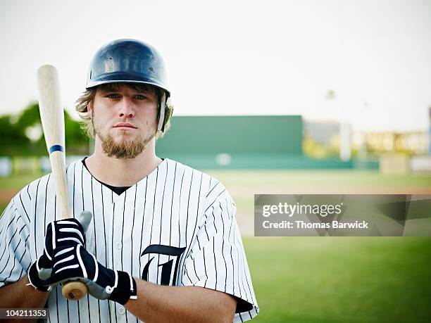 professional baseball player standing with bat - baseballschläger stock-fotos und bilder
