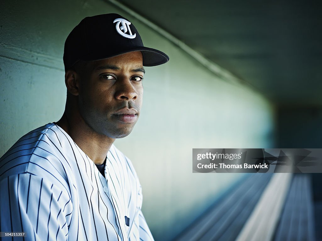 Professional baseball player sitting in dugout