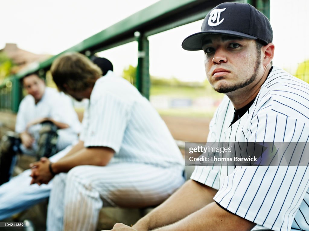 Professional baseball player sitting in dugout