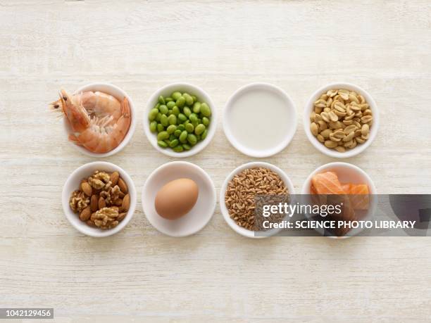 allergenic foods in bowls - voedselallergie stockfoto's en -beelden