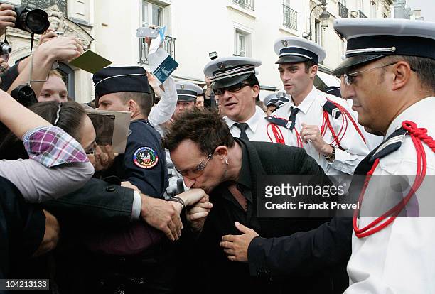 Lead singer Bono of Irish rock band U2 kisses hand of a fan after he leaves the Elysee Palace on September 17, 2010 in Paris, France.