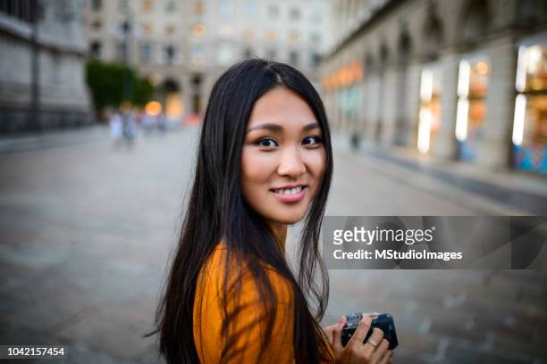 portrait of chinese woman holding camera. - singapore travel stock pictures, royalty-free photos & images
