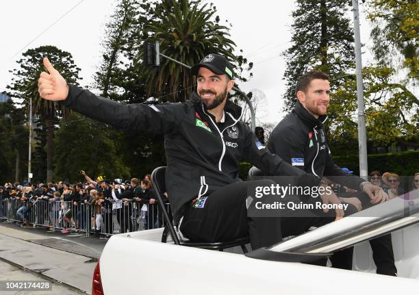 Steele Sidebottom and Jeremy Howe of the Magpies wave to the crowd during the 2018 AFL Grand Final Parade on September 28, 2018 in Melbourne,...