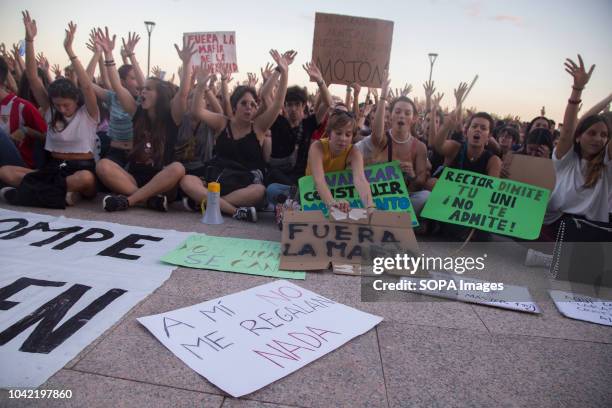 Students seen sitting down with their hands raised next to banners and posters in front of the university rectory during a strike by students of the...