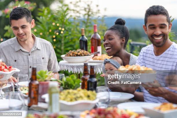 eine gruppe von jungen erwachsenen freunden essen im freien auf der terrasse - filipino family dinner stock-fotos und bilder