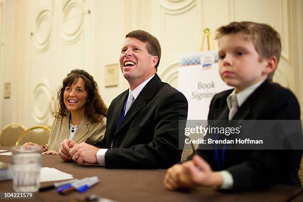 Michelle Duggar and Jim Bob Duggar, stars of The Learning Channel TV show "19 Kids and Counting," pose for a picture with a fan while signing copies...