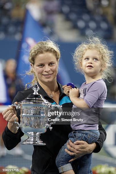 Belgium Kim Clijsters victorious, holding trophy with daughter Jada Ellie after winning Women's Final vs Russia Vera Zvonareva at BJK National Tennis...